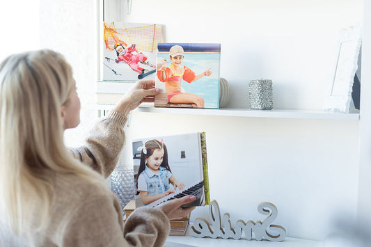 Young woman hanging a photo canvas in wall